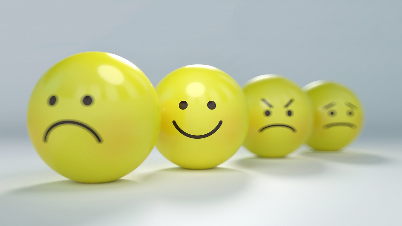 Cuatro pelotas amarillas pintadas en negro que representan las emociones de tristeza, alegría, enfado y miedo.